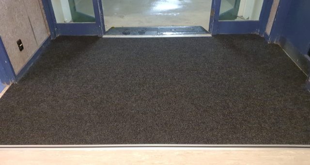 Slimrib outdoor carpet with carpet reducer bar installed in a recessed well.